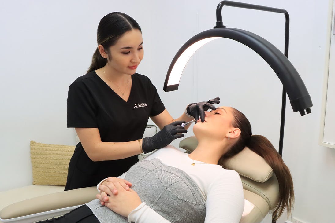 a beauty technician injecting a patient in the chin